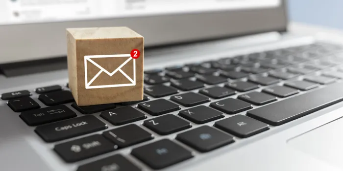 email symbol on wooden block showing new message on laptop keyboard email symbol on wooden block showing new message on laptop keyboard