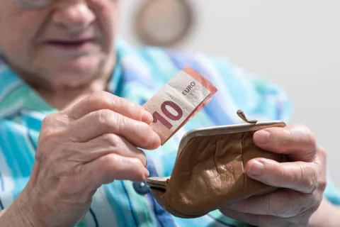 senior woman taking out a banknote from her wallet senior woman taking out a banknote from her wallet