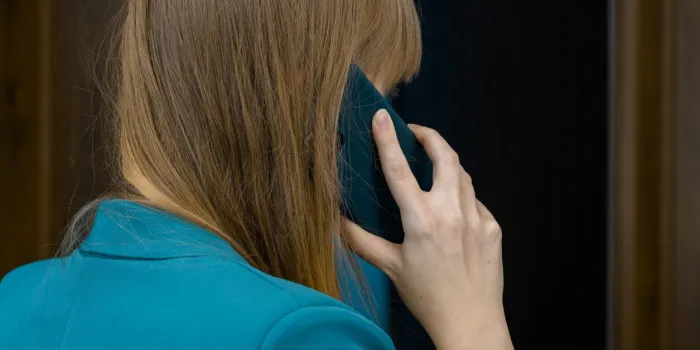 call a woman holds a mobile phone to her ear call a woman holds a mobile phone to her ear