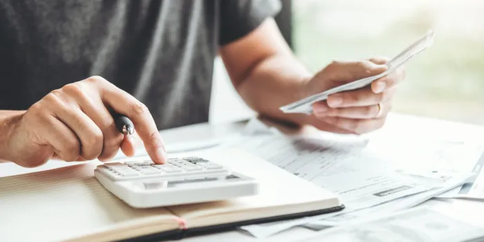 man using calculator accounting calculating cost economic bills with money stack step growing growth saving money in home , finance concept